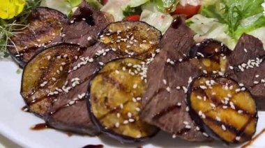 Izgara et ve taze sebzelerden oluşan parlak bir tabak, şehir festivalinde sokakta düzenlenen dönüşümlü barbekü partileri ve toplantılar için ideal. Kızarmış biftek ve patlıcan.