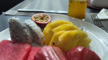 Beyaz ejderha meyvesi, karpuz, ananas parçaları ve tutku meyvesi suyu her şeyi kapsayan otel restoranında kahvaltıyla birlikte lezzetlidir. Yüksek kalite 4k görüntü