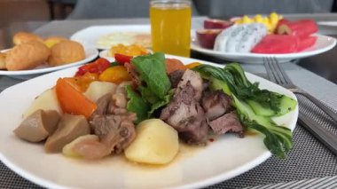 Tabakta patates, havuç, brokoli, sığır eti, portakal suyu, her şeyi kapsayan bir otel restoranında lezzetli sağlıklı bir kahvaltı. Yüksek kalite 4k görüntü