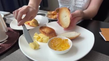 Bir parça kızarmış ekmeğe yumuşak tereyağı sürüyorum. Kahvaltı tostu yapıyorum. Yüksek kalite 4k görüntü