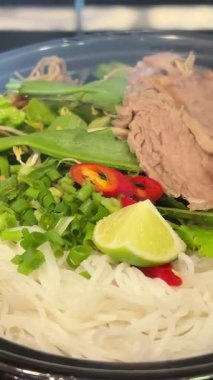 İyi aydınlatılmış Bangkok restoranında Vietnamlı pho bo çorba kasesi ve körili şehriyeli Asya çorbası hazırlama, yakın plan çekimlerde çekildi. Yüksek kalite 4k görüntü