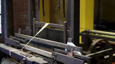 Cinematic video of silkworms hatching, feeding on mulberry leaves, spinning cocoons, and silk threads being reeled and woven into traditional Vietnamese textiles.