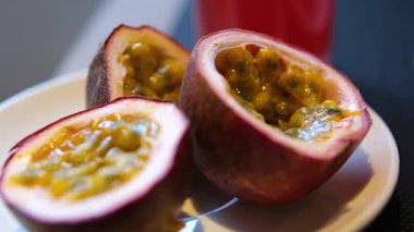 Tutku meyveleri, tutku meyveleri ve tutku meyveleri içeren olgun meyveler gri bir taş masanın üzerindeki çerçevede yavaşça hareket eder. Projelerin için egzotik meyve arkaplanı. Makro video çekimi. 4k