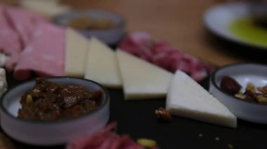 Gıda trend hediye aperatifi parti fikri. Aperatifler ahşap otlatma tahtası ile farklı şarküteri aperatifleri ve peynirler. Çeşit çeşit peynir tabağı. Düzensiz yemek. Yüksek kalite 4k görüntü