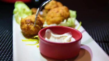 Hamur hamurunda lahana lezzetli ve kızarmış peynir topları ile domates sosu ile servis edilir. Yüksek kalite 4k görüntü