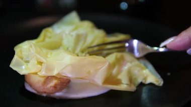 Karamelli armudu çıtır börek ve siyah tabakta kremalı şurupla kapat. Çatalla kırılan kadın eliyle enfes bir tatlı restoranı videosu..