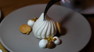 Bir çatalla iki parçaya bölünmüş tabaktaki narin beyaz marşmelov. Yüksek kalite 4k görüntü