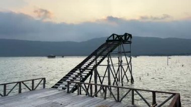 Vietnam 'da günbatımında sakin denizin üzerindeki güverteye çıkan ahşap iskele ve merdiven. Phu Quoc adasında mavi gökyüzü tropikal manzara seyahat noktası..