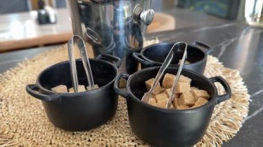 Esmer şeker kareleri, insanlar için bir kafede makas çay, pizza ve çeşitli çatal bıçaklarla servis ediliyor. Yüksek kalite 4k görüntü