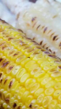 Tavada ızgara mısır. Sıcak bir tavada ızgara mısır koçanları pişiyor, sıcak bir mutfak ortamında yakın plan çekiliyor. Yüksek kalite 4k görüntü