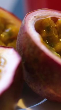 Tutku meyveleri, tutku meyveleri ve tutku meyveleri içeren olgun meyveler gri bir taş masanın üzerindeki çerçevede yavaşça hareket eder. Projelerin için egzotik meyve arkaplanı. Makro video çekimi. 4k