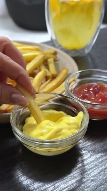 Manzara iştah açıcı, soslu patates kızartması, adam mayonezli patates kızartması yiyor. Fast food. Yüksek kalite 4k görüntü