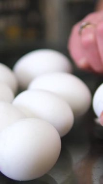 Açık tenli insanın genel görünümü, haşlanmış yumurtayı kabuğun üzerine kabuk parçaları, patates ve boş tabağın yanına serpiştirmeye odaklı. Yüksek kalite 4k