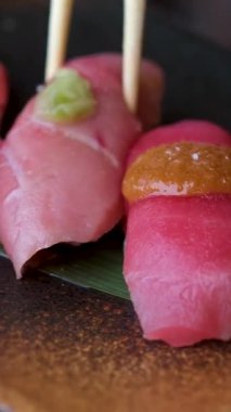 Chopstickler Japon restoranında Japon suşisi yer. Geleneksel suşi Maki Rolls Suşi Suşi Salmon Philadelphia Peyniri Avokado, Salatalık, Pirinç ve Nori. Japon Yemeği Suşi Roll Uramaki, Nigiri 