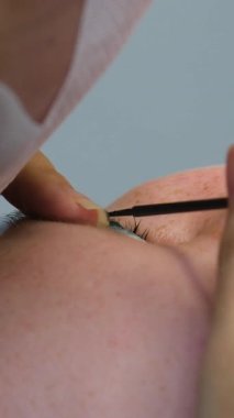 Kirpik uzatma prosedürü. Uzun kirpikli kadın gözü. Kırbaç, yakın çekim, seçici odaklanma. Yüksek kalite 4k görüntü
