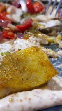 Ekşi krema ve salatalık tabakta. Bir kadın ekşi krema soslu beyaz balık salatası yiyor..