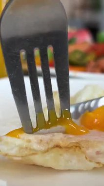 Kahvaltıda çırpılmış yumurta. Güneşli tarafı yukarıda yumurtalar nazikçe tahta kesme tahtasına konuyor, çatal delici altın sarısı taze. Yumuşak haşlanmış yumurta, tutkulu meyve suyu.