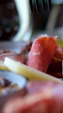 Çeşitli gurme peynirlerle dolu otel ya da restoran büfesi, hazırlanmış etler ve aperatifler seramik tabaklar üzerinde güzelce yerleştirilmiş. Yüksek kalite 4k görüntü