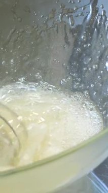 Elektrikli el mikseriyle yumuşak bir tepe dokusu yaratmak için yumurta akı çırpmak. Yüksek kalite 4k görüntü