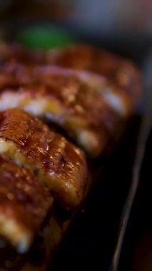 Suşi yılan balığı tabağı Şef renkli suşi rulosu mikroyeşillik ve sosla profesyonel bir mutfakta, ton balığı, avokado, yılan balığı ve somon sosu içeriyor. Yüksek kalite 4k görüntü