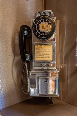 Antik ankesörlü telefonu bir telefon kulübesinde döner çeviriciyle kapat.
