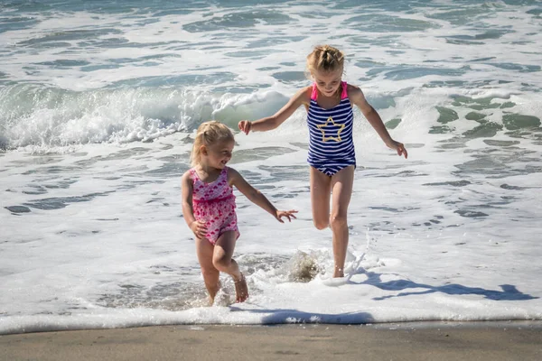 Две Девушки Убегают Океанских Волн — стоковое фото