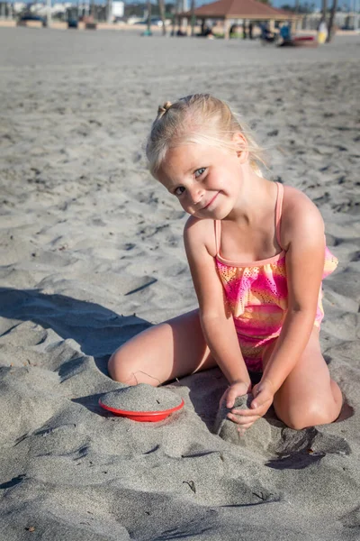 Маленькая Девочка Купальнике Играет Игрушкой Песке Улыбается Камеру Пляже — стоковое фото