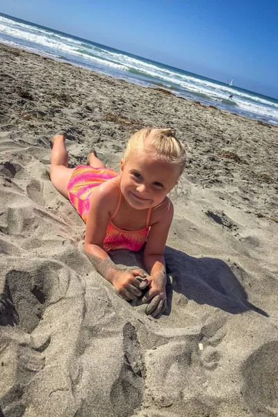 Маленькая Девочка Лежащая Песке Пляже Улыбающаяся Камеру — стоковое фото
