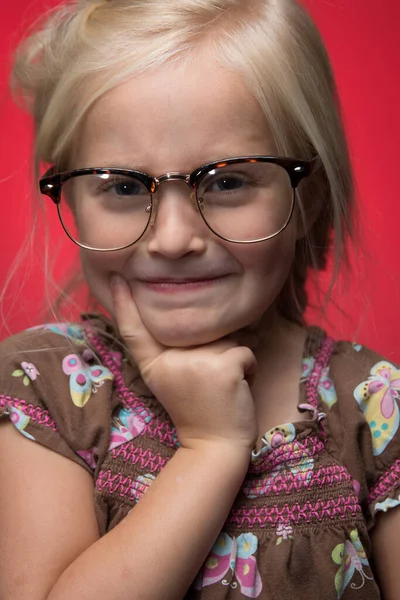 可爱的小女孩 戴着眼镜 靠着红地毯思考 — 图库照片