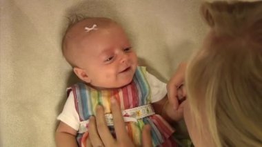 Oynarken annesine gülümseyen şirin bir bebek.