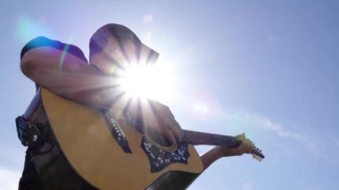 Gökyüzüne Karşı Gitar Çalan Adam Güneş Patlaması ile Arkaplanda