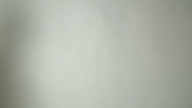 Yüz maskesi takan doktor çerçeveye girer ve kollarını çaprazlar.