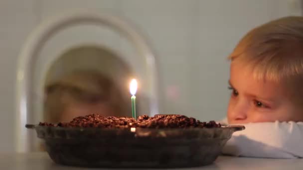 Ein Mädchen Bläst Eine Kerze Auf Einem Schokoladeneiskuchen Aus — Stockvideo