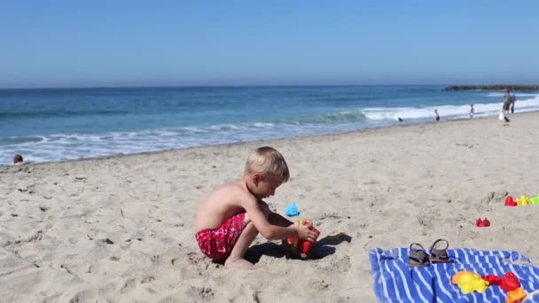 Een Jongen Die Het Zand Aan Het Strand Speelt — Stockvideo