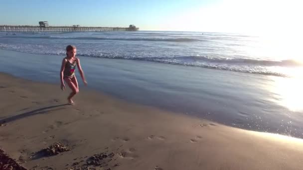 ビーチショアに沿ってカートホイールを行う女の子 — ストック動画
