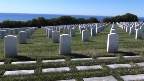 海を見下ろす崖の上の軍事用の墓石に沿ってドリーライト — ストック動画