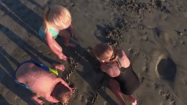 在沙中玩耍的孩子的头顶开枪 — 图库视频影像