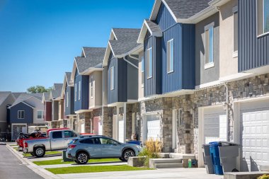 Looking down a row of colorful condo homes in the day with blue skies
