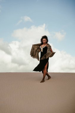 african girl with scarf in the air in the desert