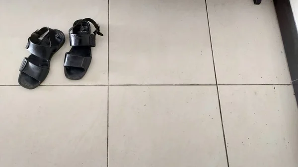 Ein Paar Schwarze Sandalen Auf Dem Boden Vor Weißem Hintergrund — Stockfoto