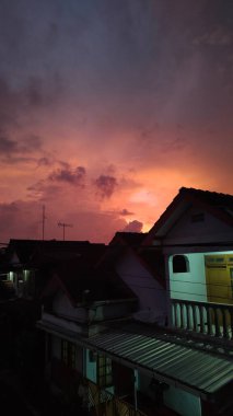 Arka planda güzel günbatımı olan çatılar.