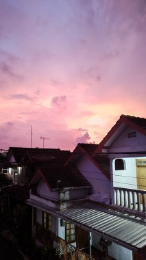 Arka planda güzel günbatımı olan çatılar.