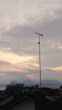 Evlerin ve antenlerin çatıları olan gri gökyüzünün manzarası