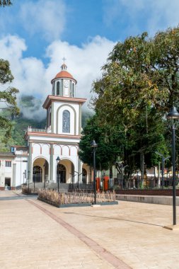 Tamesis, Antioquia, Kolombiya. 22 Haziran 2020: Ağaçları ve mavi gökyüzü olan San Antonio de Tamesis Kilisesi.