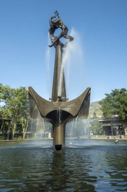 Antoquia Üniversitesi 'nde mavi gökyüzü olan enerji yaratıcısının heykeli ve çeşmesi..