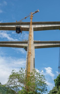 Antioquia 'nın güneybatısında mavi gökyüzü ve ağaçlarla dolu bir köprü. Kolombiya.