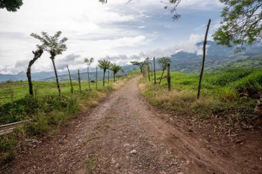 Bulutlu gökyüzü ve dağları olan güzel bir yol manzarası. Tamesis, Antioquia, Kolombiya.