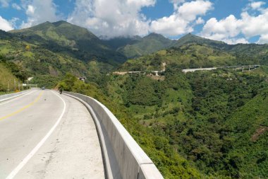 Denizden geçen yolda tepe ve mavi gökyüzü olan doğal manzara. Kolombiya.
