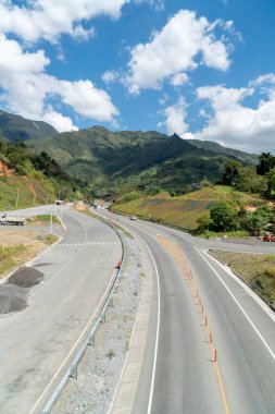 Denizden geçen yolda tepe ve mavi gökyüzü olan doğal manzara. Kolombiya.
