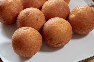 Beyaz bir tabakta ön planda Buuelos. 